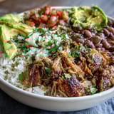 Hearty gluten-free Carnitas Bowl topped with creamy avocado slices and chopped cilantro.