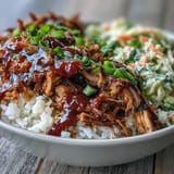 This hearty Pulled Pork Bowl features tender meat and tangy coleslaw piled high on brown rice, perfect for a family dinner.