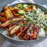 A deconstructed BBQ Chicken Bowl showing all the colorful components like zucchini, broccoli, and red onion arranged neatly for assembly. 