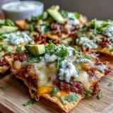 Soccer Game Day Nachos with Cheese Sauce piled high on crispy tortilla chips, loaded with jalapeños, tomatoes, and creamy avocado slices.