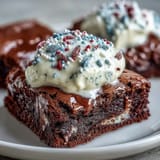 Festive 4th of July Firecracker Brownie Bites with creamy frosting and patriotic sprinkles on a red platter.