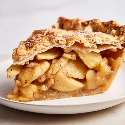 A close-up of a freshly baked apple pie, showcasing a bubbling fruit filling and crisp crust.