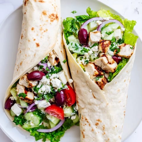 Savory Greek Lemon Chicken Salad Wrap loaded with crisp cucumbers, juicy tomatoes, and tangy feta, all snugly rolled in a warm flour tortilla.