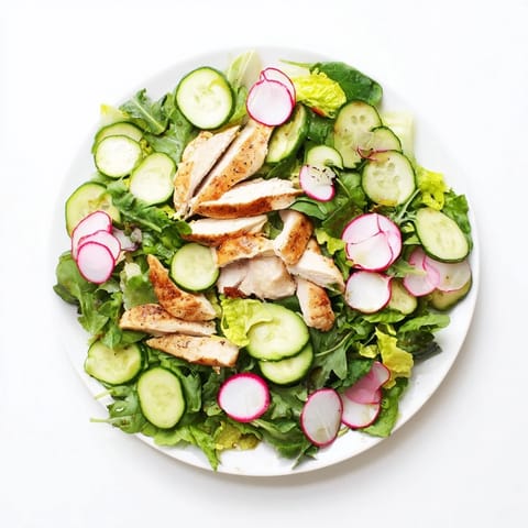 Freshly grilled chicken rests atop vibrant mixed greens, cucumber, and radish in this Spring Detox Chicken Salad, drizzled with a bright lemon vinaigrette.