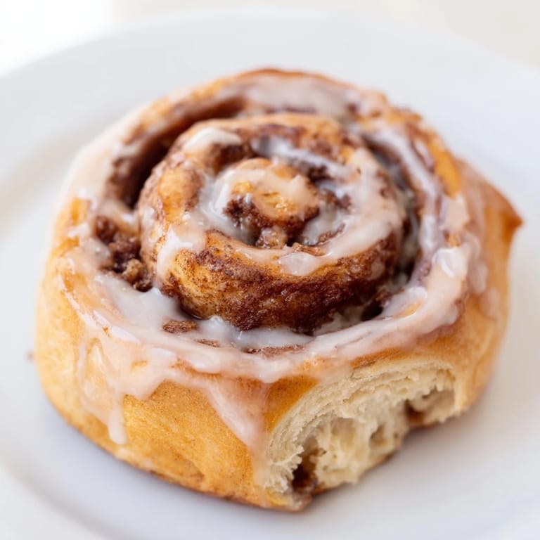 Golden and fluffy homemade Cinnamon Rolls await, their sweet cinnamon swirl a tasty breakfast treat.