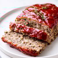Delicious, juicy meatloaf glistening with a sweet and tangy ketchup glaze, ready for dinner.