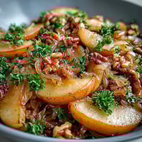 Golden Honeycrisp apples and red onions sautéed in a skillet, mixed with tangy sauerkraut, topped with fresh parsley and toasted walnuts.  