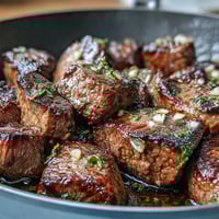 One-pan garlic herb steak bites with juicy seared sirloin and aromatic butter sauce.