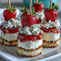 Mini Strawberry Shortcake Bites skewers with fresh berries and fluffy whipped cream.